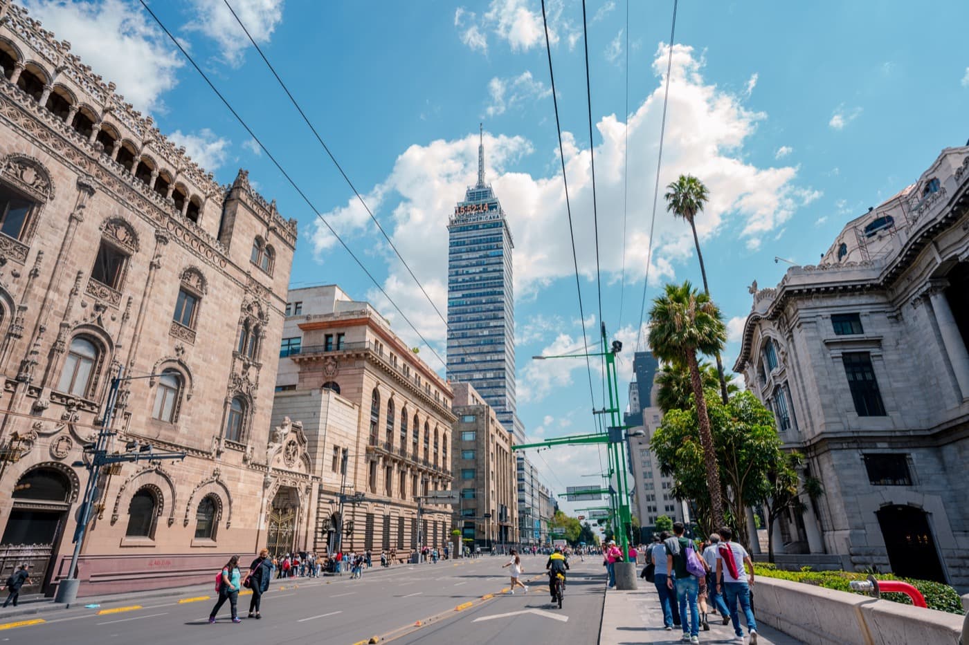 A tower and old buildings on a street in Mexico City