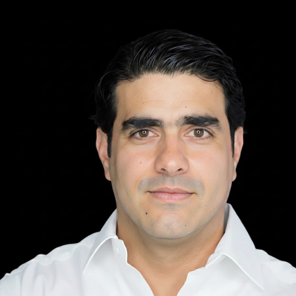 Portrait of Eduardo Santoy in a white shirt against a black backdrop