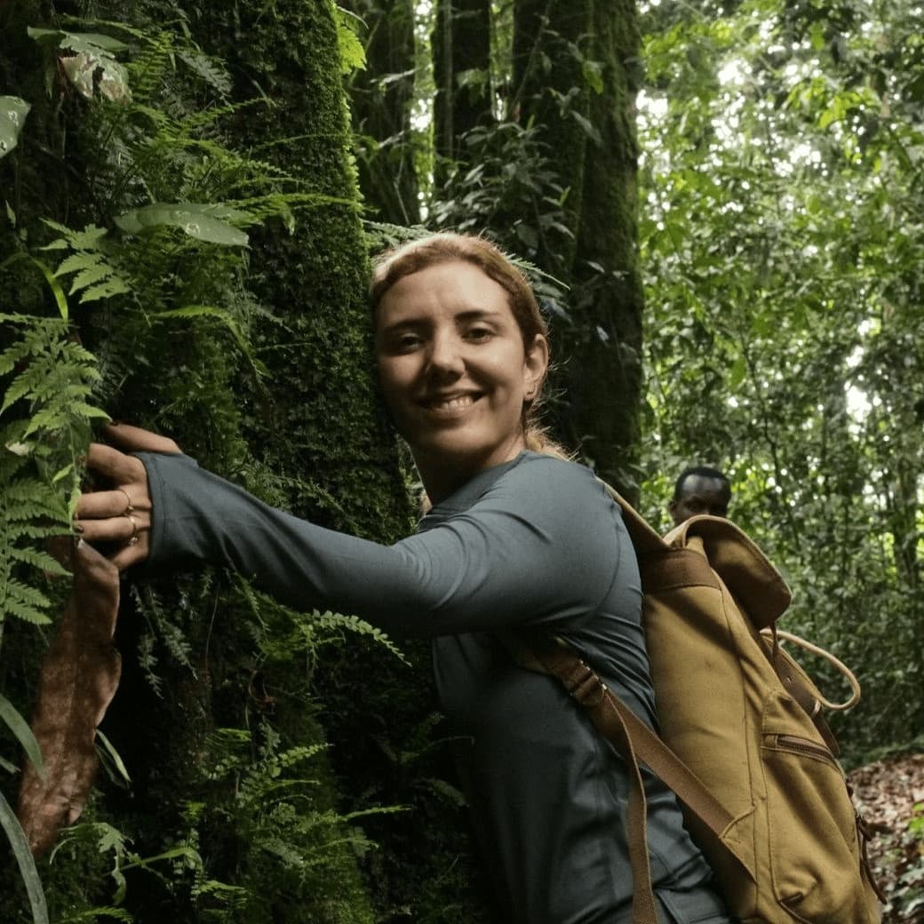 Portrait of Lorenia Bay hugging a tree in a rainforest