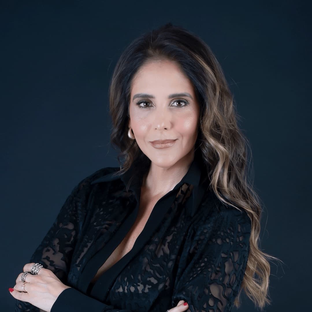 Portrait of Magda Fernandez in a black lace top with her arms crossed