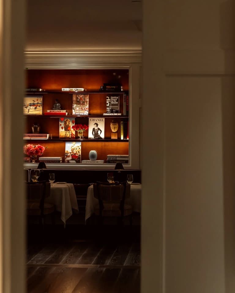 A bar with a lit shelf of bottles in a warm wood interior